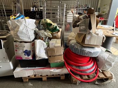 une pile de cartons et de tuyaux posée sur une palette dans un entrepôt