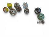several different colored glass beads are arranged on a white surface