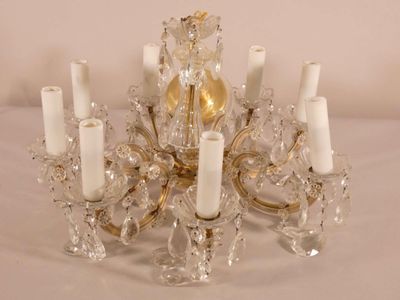 un lustre en cristal avec des bougies posées sur une table blanche