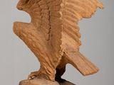 a wooden sculpture of an eagle that is sitting on a table