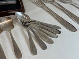 a lot of silver spoons and spoon spoons on the table