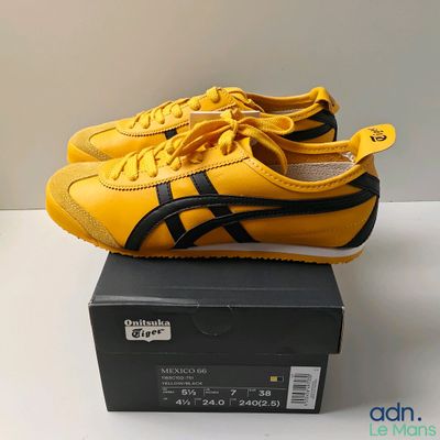 yellow and black onitsuka sneakers on a box on a white surface