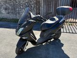 un scooter garé devant une clôture