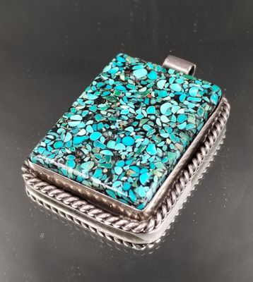 un pendentif carré en pierre turquoise, monté sur un cadre en corde