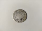 a silver coin sitting on top of a white surface
