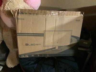 un ours en peluche qui tient une boîte sur laquelle est posé un ordinateur