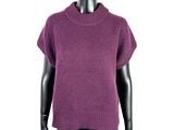 Le mannequin porte un pull violet et un legging noir.