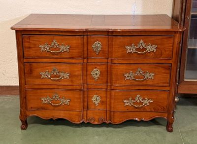 une commode en bois avec de nombreux tiroirs dans une pièce