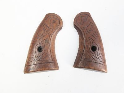 deux poignées en bois ornées de sculptures sur un fond blanc