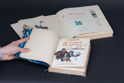 une personne tenant un livre ouvert sur une table