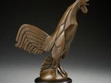 a bronze statue of a rooster on a black pedestal