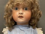 doll with blonde hair and blue shirt with ruffles on it