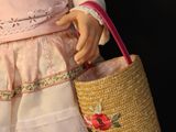 a doll that is holding a basket in her hand