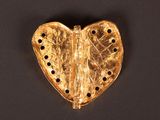 an image of a gold heart shaped object on a black surface