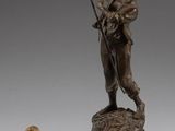 deux statues en bronze représentant un homme muni d'un bâton et une statue représentant une femme tenant un bâton