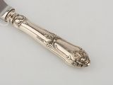 an antique silver plate with a knife and fork on a white surface