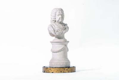 white marble bust of a woman on a pedestal on a white background