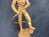 gold statue of a man with a hose on top of a pedestal