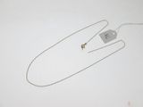 a necklace with a tag attached to it on a white surface