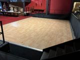 a wooden floor in the middle of a large room