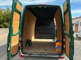 a green van with its doors open in a parking lot