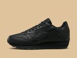 une basket en cuir noir avec une semelle noire et des lacets noirs
