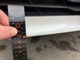 someone is measuring the width of a car with a ruler