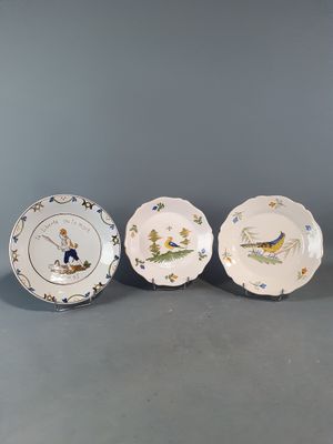 trois assiettes ornées d'oiseaux et de fleurs, posées sur une table