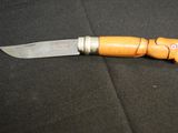 a knife with a wooden handle on a black surface