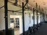 une photo d'une salle de sport avec une rangée d'haltères