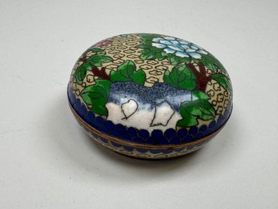 une petite boîte bleue et blanche décorée de fleurs