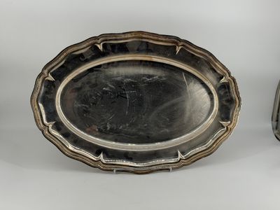 two silver trays sitting on top of a table next to each other