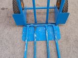 a blue hand truck that is sitting on the floor
