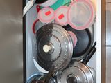 many pots and pans in the bottom drawer of a cabinet