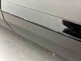 a black cat that is sitting on the side of a car