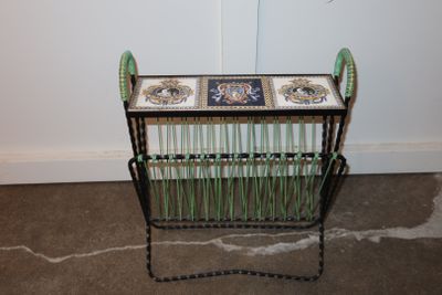 a small table with a basket on it in the corner of a room