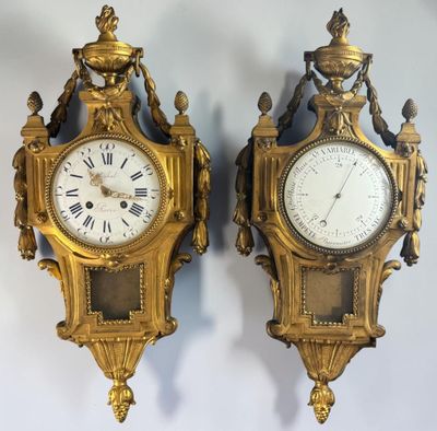 pair of antique clocks on a wall with roman numerals on each of them