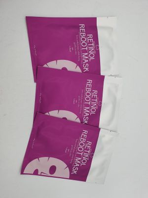 trois paquets de masques pour le visage sont posés sur une surface blanche