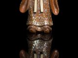 chinese figurine of a man holding a fish on a black surface