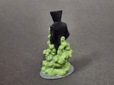a small figurine of a man standing on a pile of green stuff