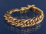 un gros plan d'un bracelet en or sur un fond bleu