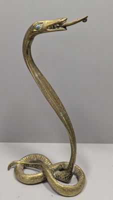 une image représentant une statue de serpent en laiton avec un œil bleu