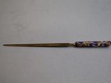 a purple and blue bead on the tip of a needle