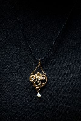 une femme portant un t-shirt noir et un collier en or
