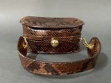 brown snake skin purse with gold chain strap on grey background