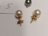 two pairs of pearl and gold earrings on a white surface
