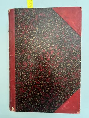 un vieux livre à la couverture rouge posé sur une table
