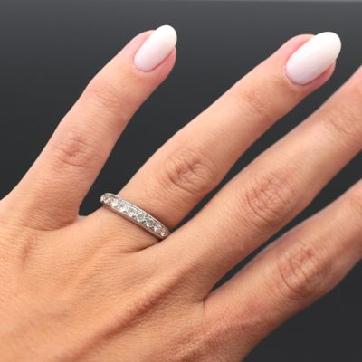 a woman ' s hand with a white manicure and a diamond ring