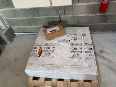 un matelas posé sur une palette, sur laquelle se trouve une boîte