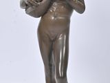 an antique bronze statue of a woman holding a basket of flowers